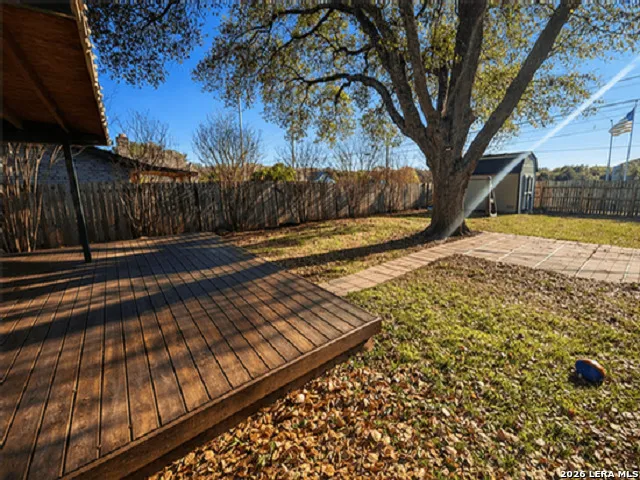 a view of a yard with wooden fence