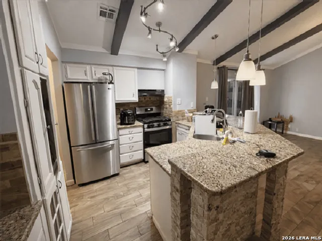 a kitchen with stainless steel appliances granite countertop a sink stove and refrigerator