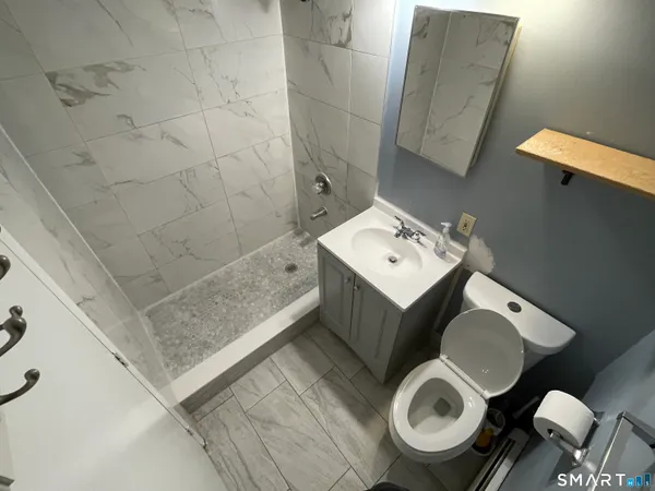 a bathroom with a toilet sink and mirror