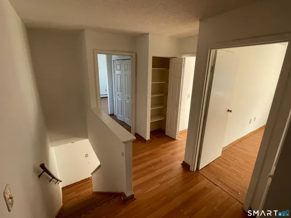 a view of front door with wooden floor and stairs