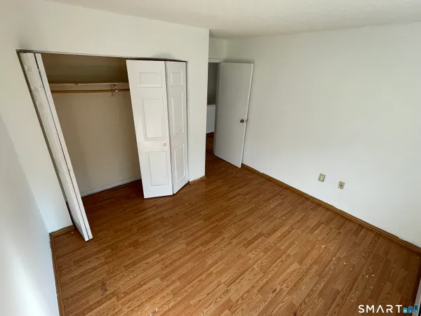 an empty room with wooden floor and entrance