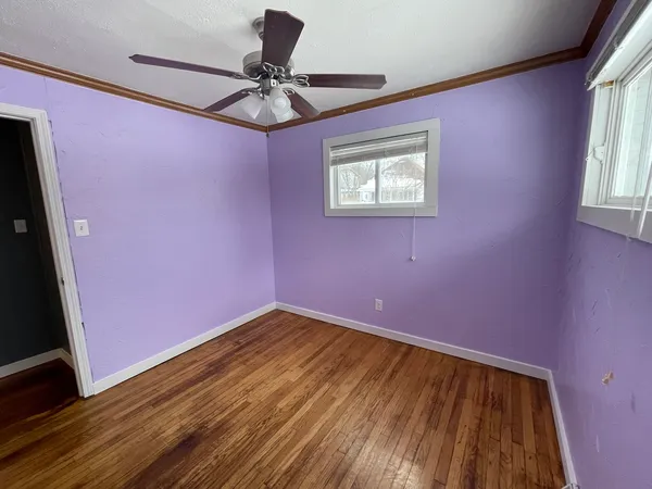 a view of empty room with a window and wooden floor
