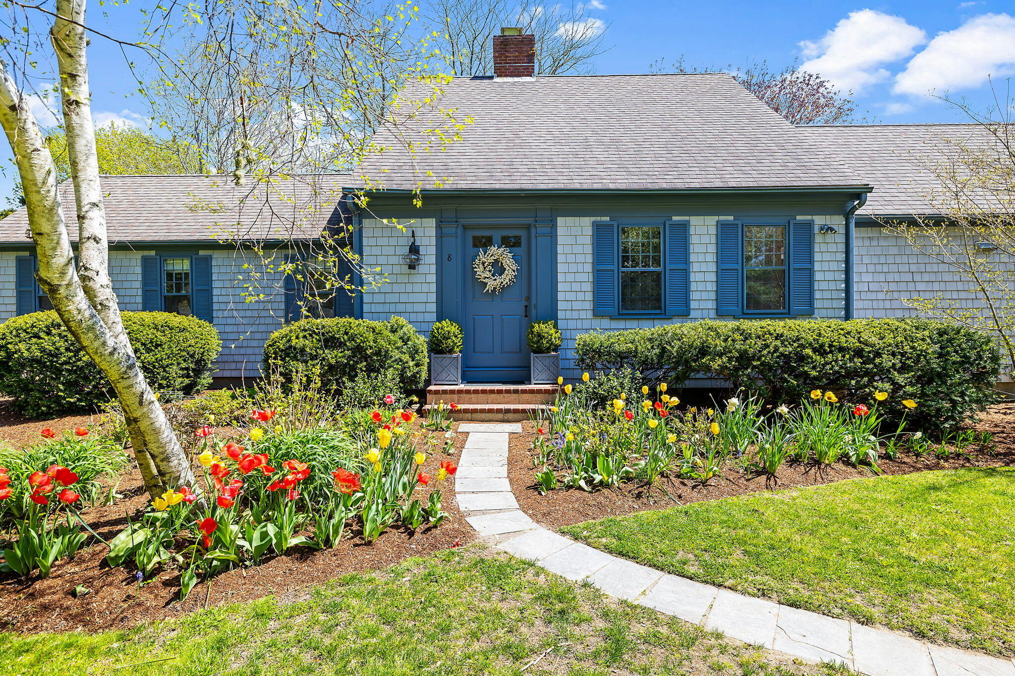 a front view of a house with a yard and flowers