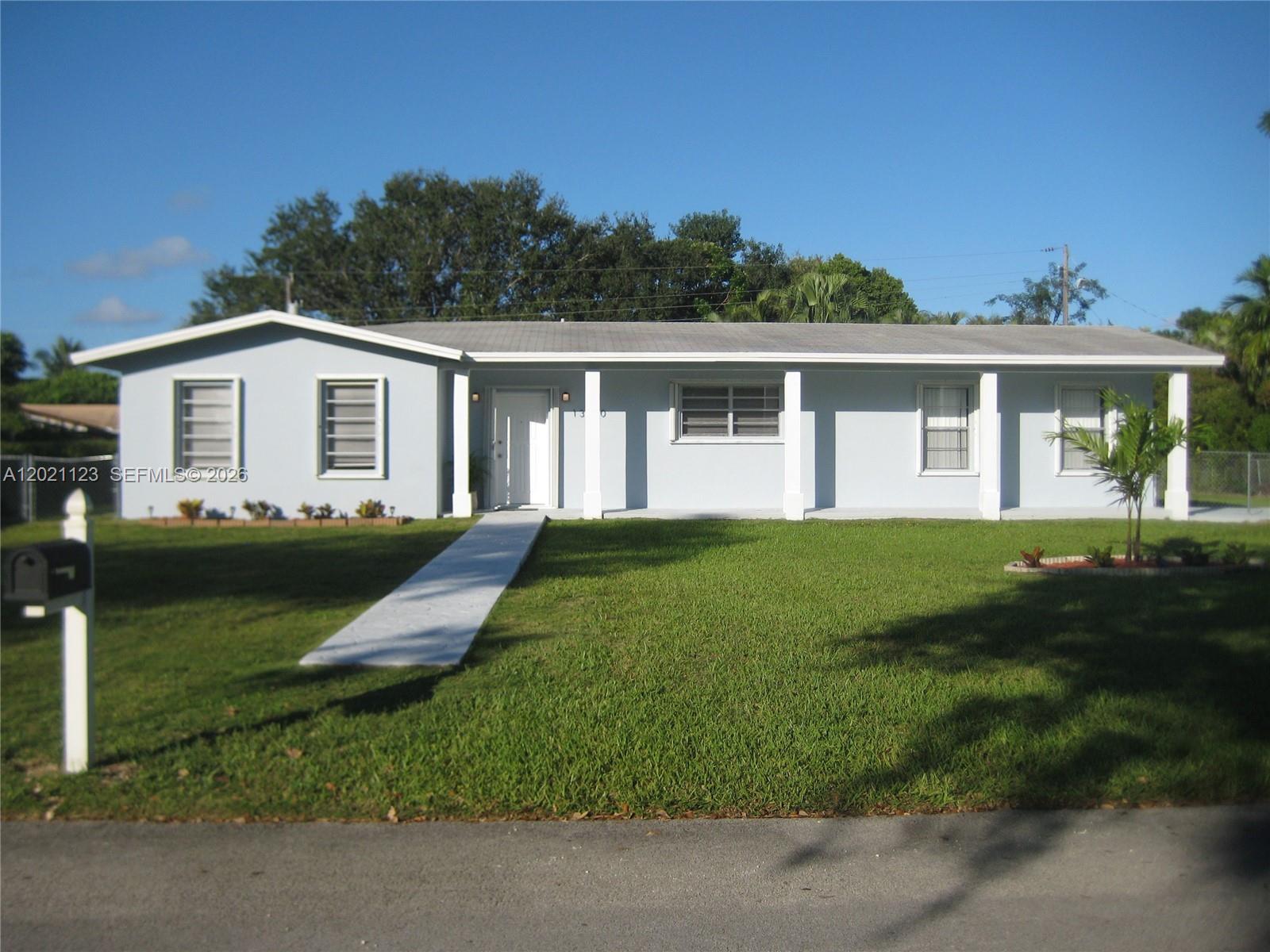 13220 Southwest 99th Place Miami, FL 33176 - Photo 1 of 16 a front view of a house with a garden and trees
