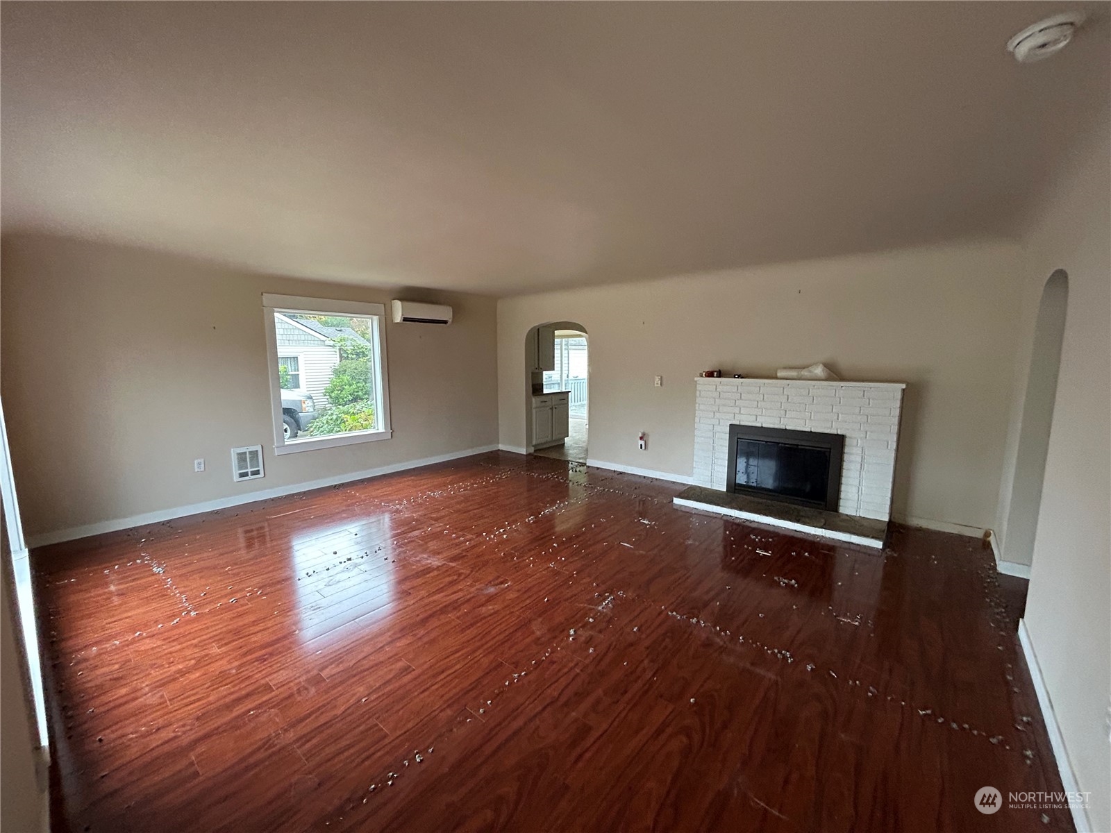 6919 Cady Road Everett, WA 98203 - Photo 3 of 29 an empty room with wooden floor fireplace and windows