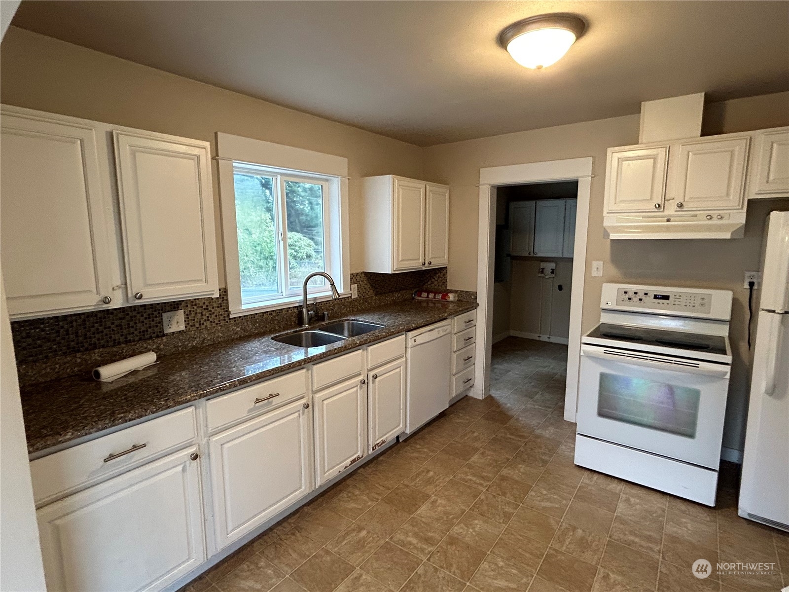 6919 Cady Road Everett, WA 98203 - Photo 7 of 29 a kitchen with granite countertop white cabinets and white appliances
