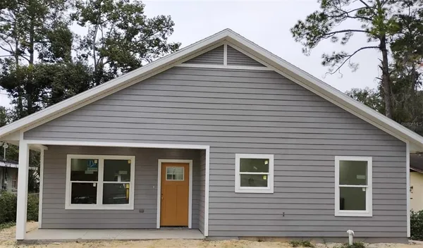 a front view of a house with a tree
