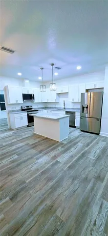 a large kitchen with kitchen island a sink stainless steel appliances and cabinets