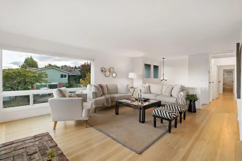 a living room with furniture and a floor to ceiling window