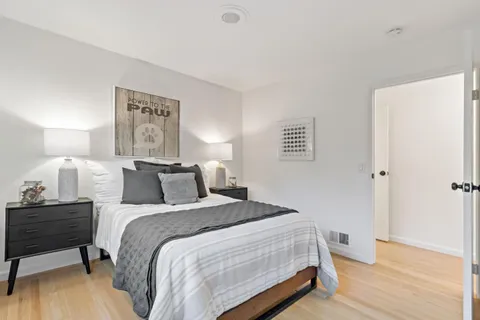 a bedroom with bed and wooden floor