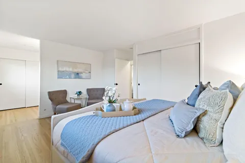 a bedroom with a bed and wooden floor