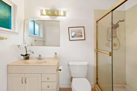 a bathroom with a sink a toilet and shower