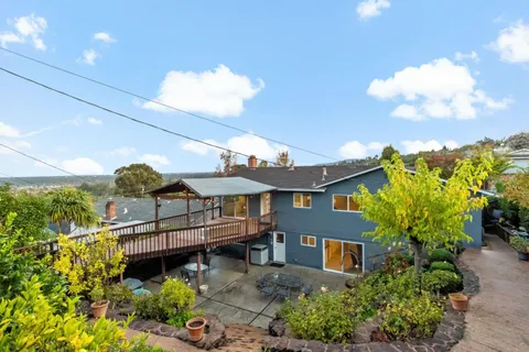 a view of a house with a big yard and a garden