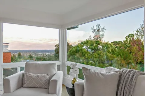 a balcony with furniture and a large window