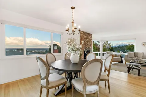 a dining room with furniture a chandelier and wooden floor