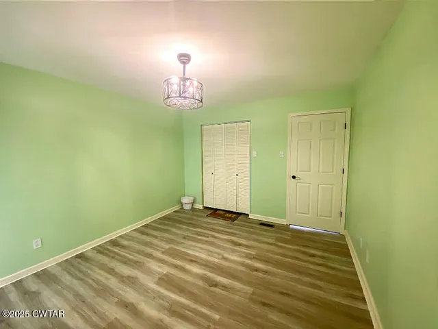 a bedroom with a large bed and a flat tv screen on dresser