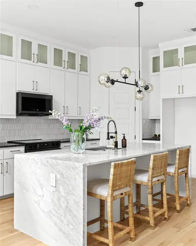a kitchen with stainless steel appliances kitchen island granite countertop a table and chairs
