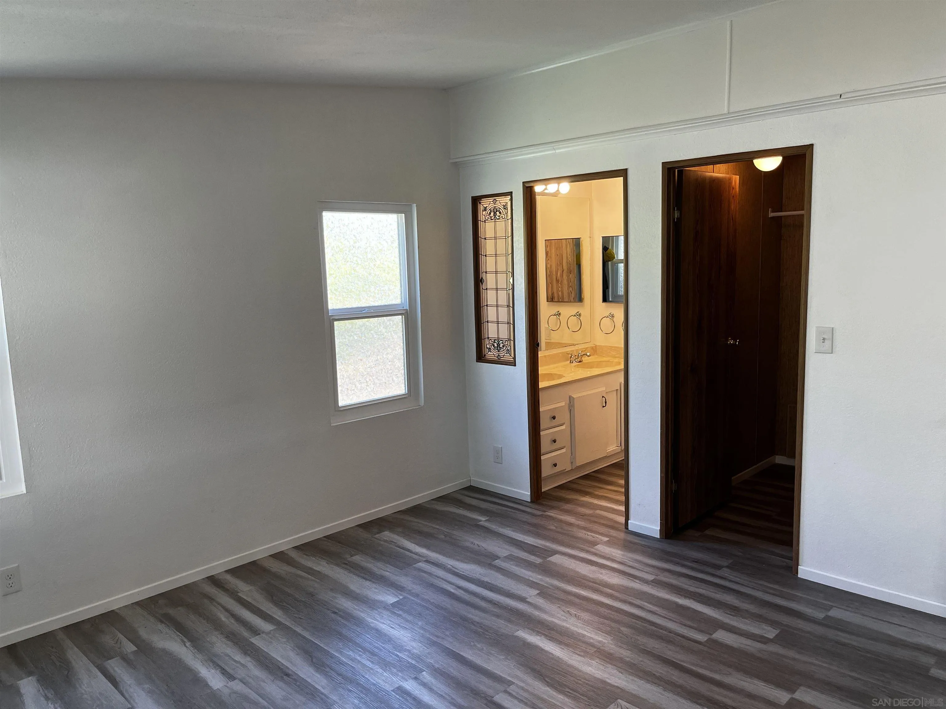 909 Richland Road, Unit 134 San Marcos, CA 92069 - Photo 11 of 44 an empty room with wooden floor and windows