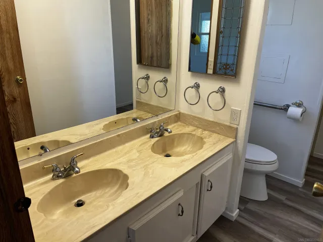 a bathroom with a granite countertop sink toilet and shower