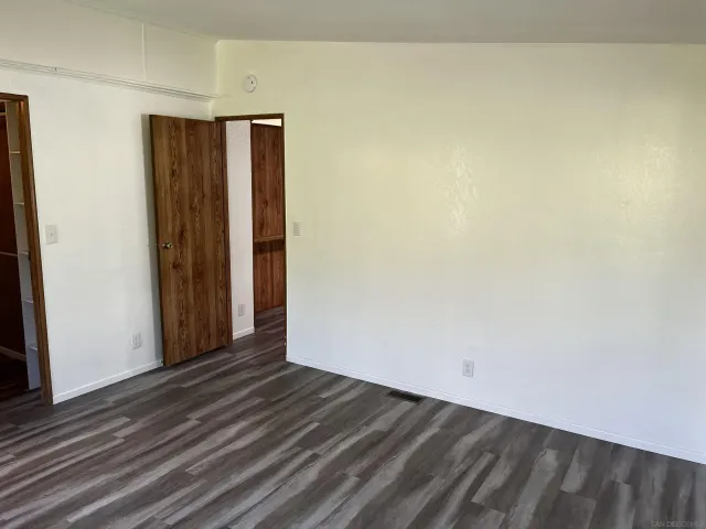 a view of a hallway with wooden floor and chandelier