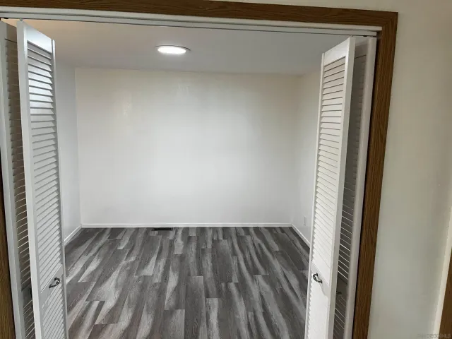 a view of empty room with window and wooden floor