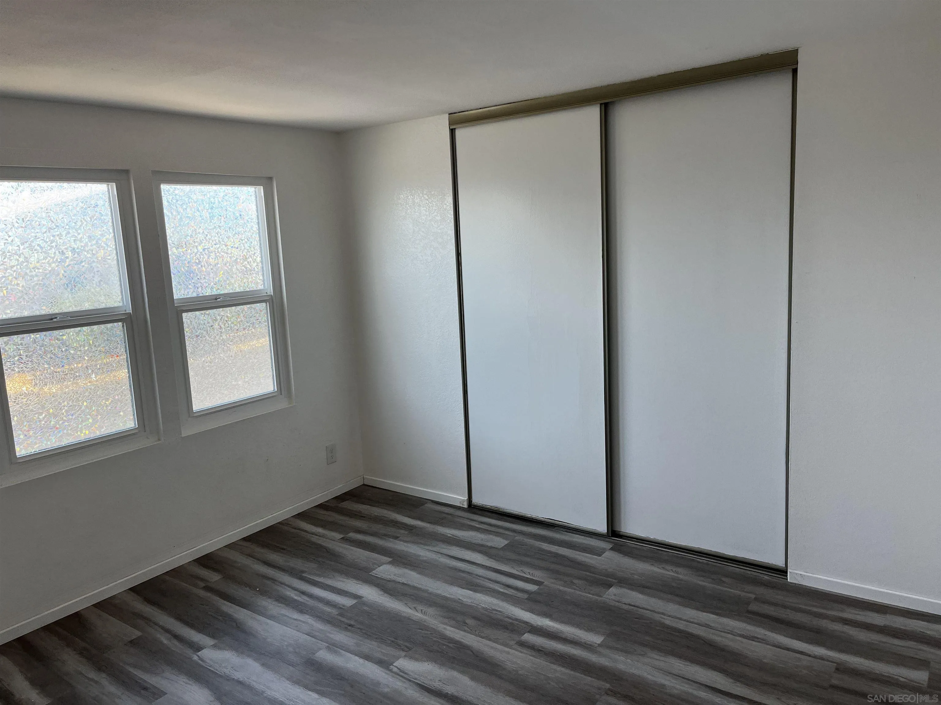 909 Richland Road, Unit 134 San Marcos, CA 92069 - Photo 8 of 44 a view of an empty room with wooden floor and a window