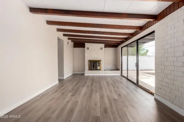 a view of empty room with wooden floor and fireplace