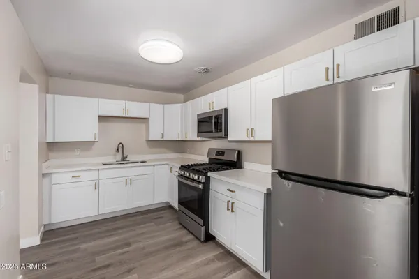 a kitchen with white cabinets and stainless steel appliances