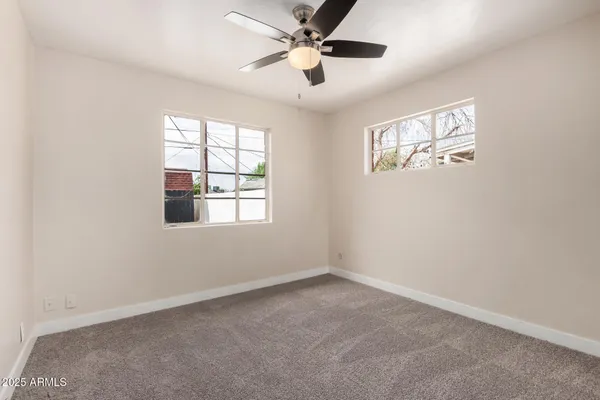 an empty room with a window and a fan