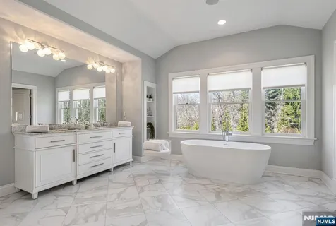a bathroom with a bathtub sink and mirror
