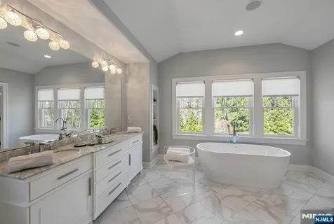 a spacious bathroom with a large tub sink and window