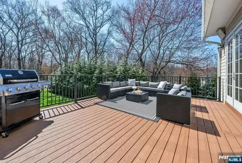 a view of a roof deck with couches fire pit and wooden floor