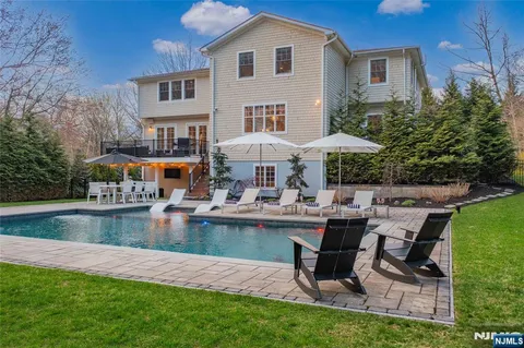 a view of a house with pool and chairs