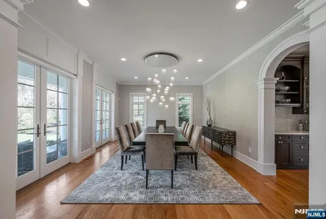 a dining room with wooden floor and a chandelier