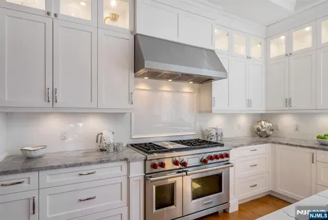 a kitchen with white cabinets and appliances