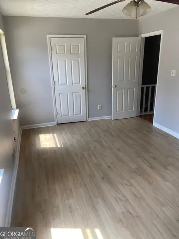 a view of hallway with wooden floor and stairs