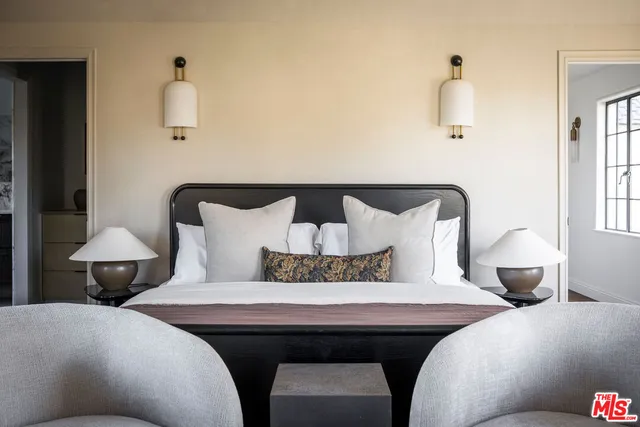 a bedroom with bed and a lamp on table