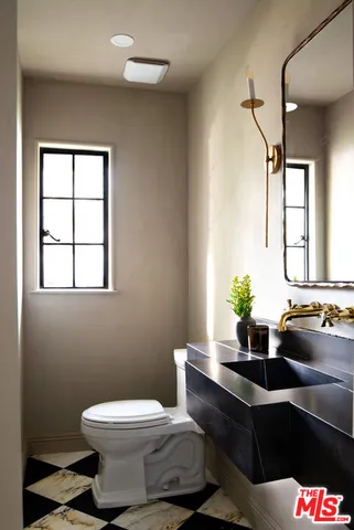 a bathroom with a toilet sink and mirror