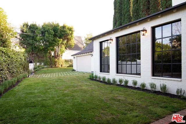 a front view of a house with a yard and plants
