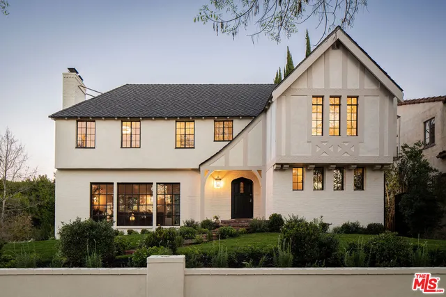 a view of a white house next to a yard