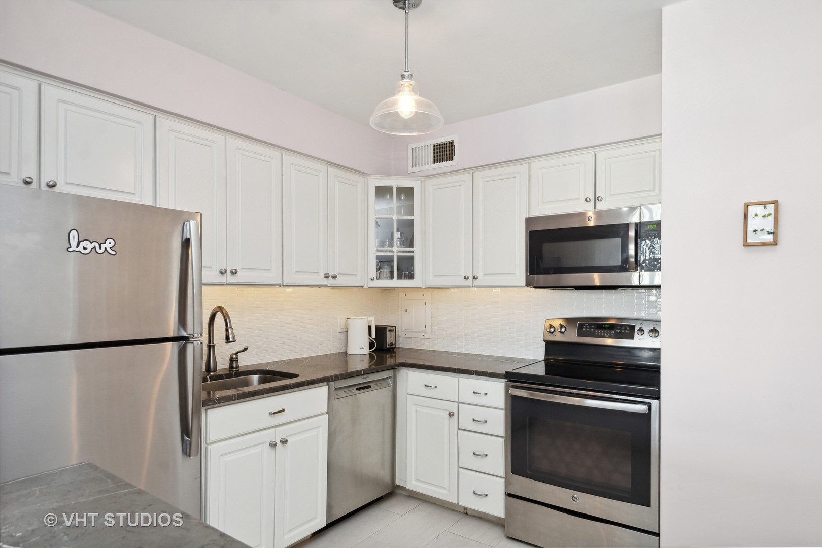 30 East Elm Street, Unit 18A Chicago, IL 60611 - Photo 6 of 16 a kitchen with stainless steel appliances white cabinets and a sink
