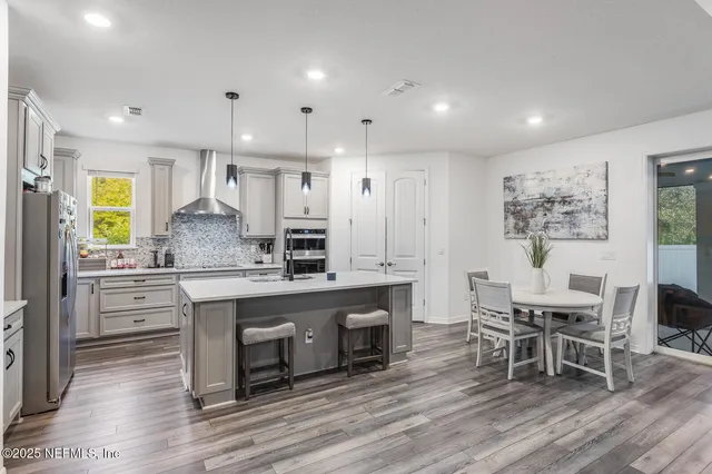 a kitchen with kitchen island granite countertop a sink and a refrigerator
