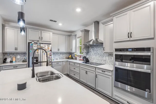 a kitchen with granite countertop a sink stainless steel appliances and cabinets