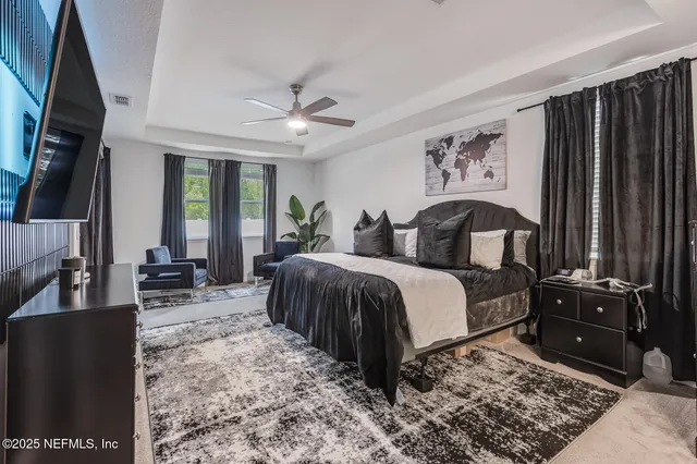 a bedroom with a bed a dresser and potted plants