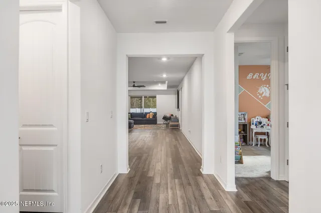 a view of a hallway with wooden floor and furniture
