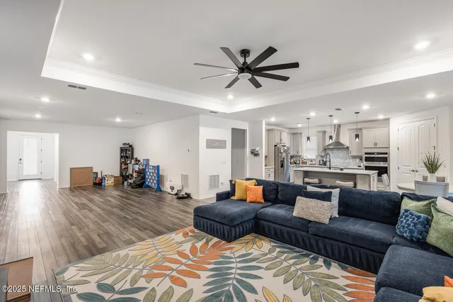 a living room with furniture and a view of kitchen
