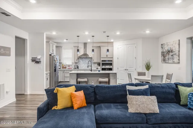 a living room with stainless steel appliances kitchen island granite countertop furniture and view of kitchen