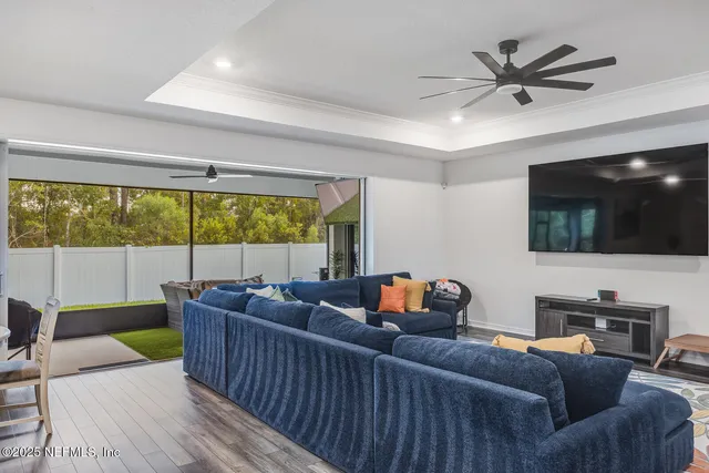 a living room with furniture a flat screen tv and a large window