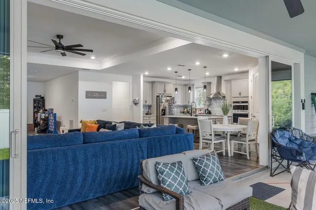 a living room with furniture a dining table and chairs with wooden floor