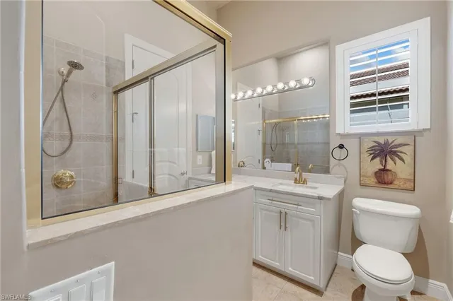 a bathroom with a granite countertop toilet a sink and a mirror